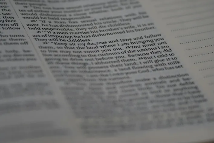 Close-up view of Holy Bible text with soft focus creating a spiritual ambiance.
