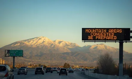Traffic on a California highway with mountain view and LED display warning. Ideal for travel and commuter themes.