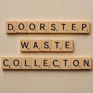 Arrangement of wooden letter tiles spelling trash on a wooden table surface.