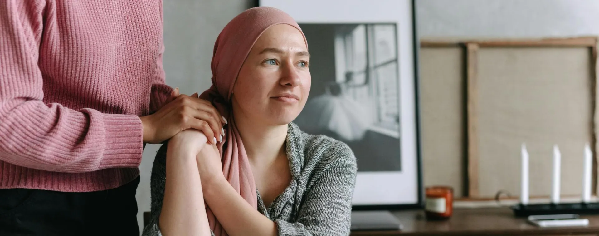 A supportive moment indoors featuring a cancer patient be comforted by The Pop In Concierge, conveying emotion and care.