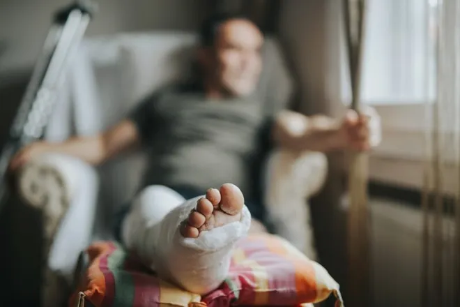 Man watching out the window and healing after broken leg as the Pop In Concierge Service leaves for the day