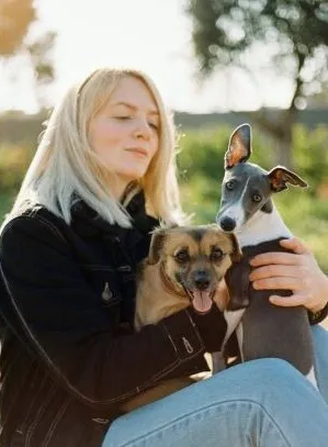 A young woman enjoying a day outdoors with her two dogs once finding the Pop In Concierge Service