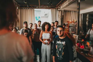 A diverse group attentively listening to a seminar in a spacious indoor setting in São Paulo.