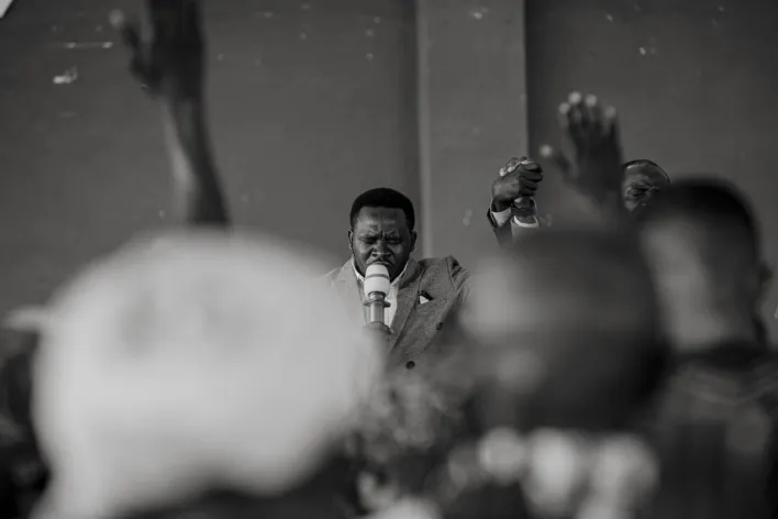 A passionate moment during a worship service with raised hands and a microphone.
