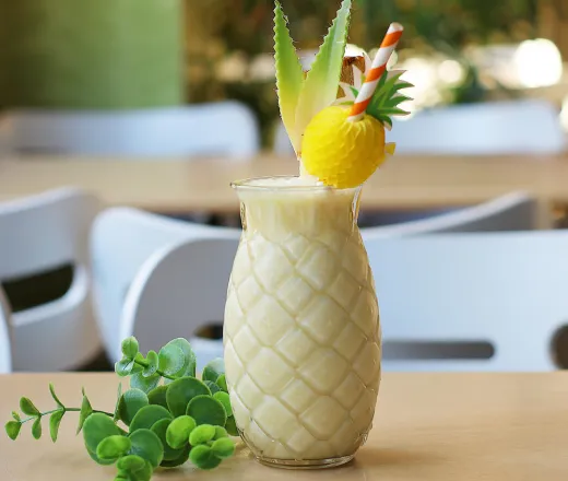 Refreshing tropical pineapple cocktail with fresh garnish served in a decorative glass indoors.