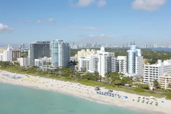 Stunning aerial shot of Miami Beach skyline with bright blue skies and sandy coastlines.