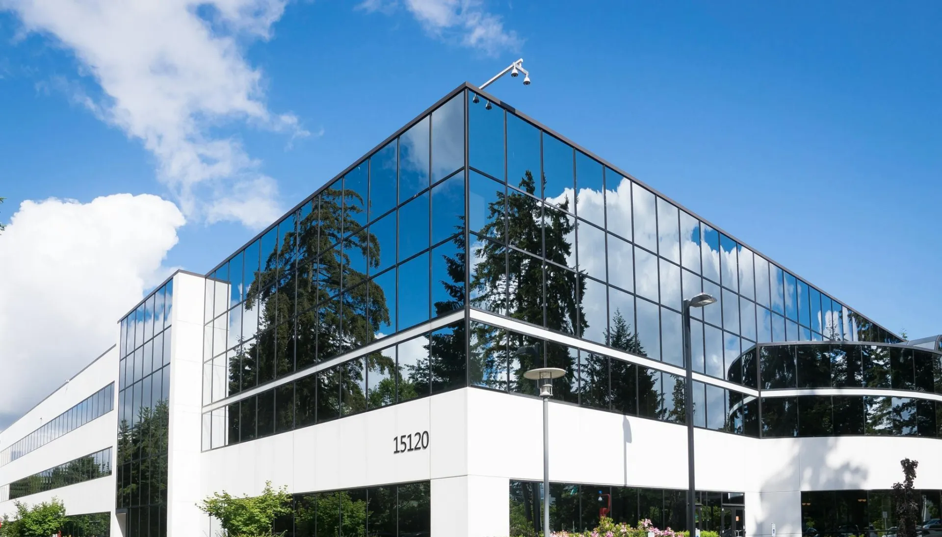 Contemporary office building in Redmond with reflective glass and lush greenery, captured on a sunny day.