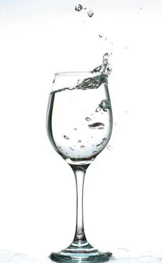 A captivating image of water splashing inside a wine glass against a white background.