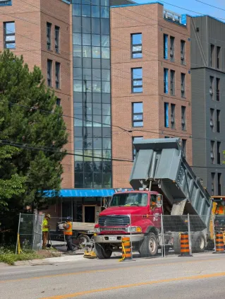 Vibrant construction scene in Kingston, Ontario, showcasing an urban development with heavy machinery.