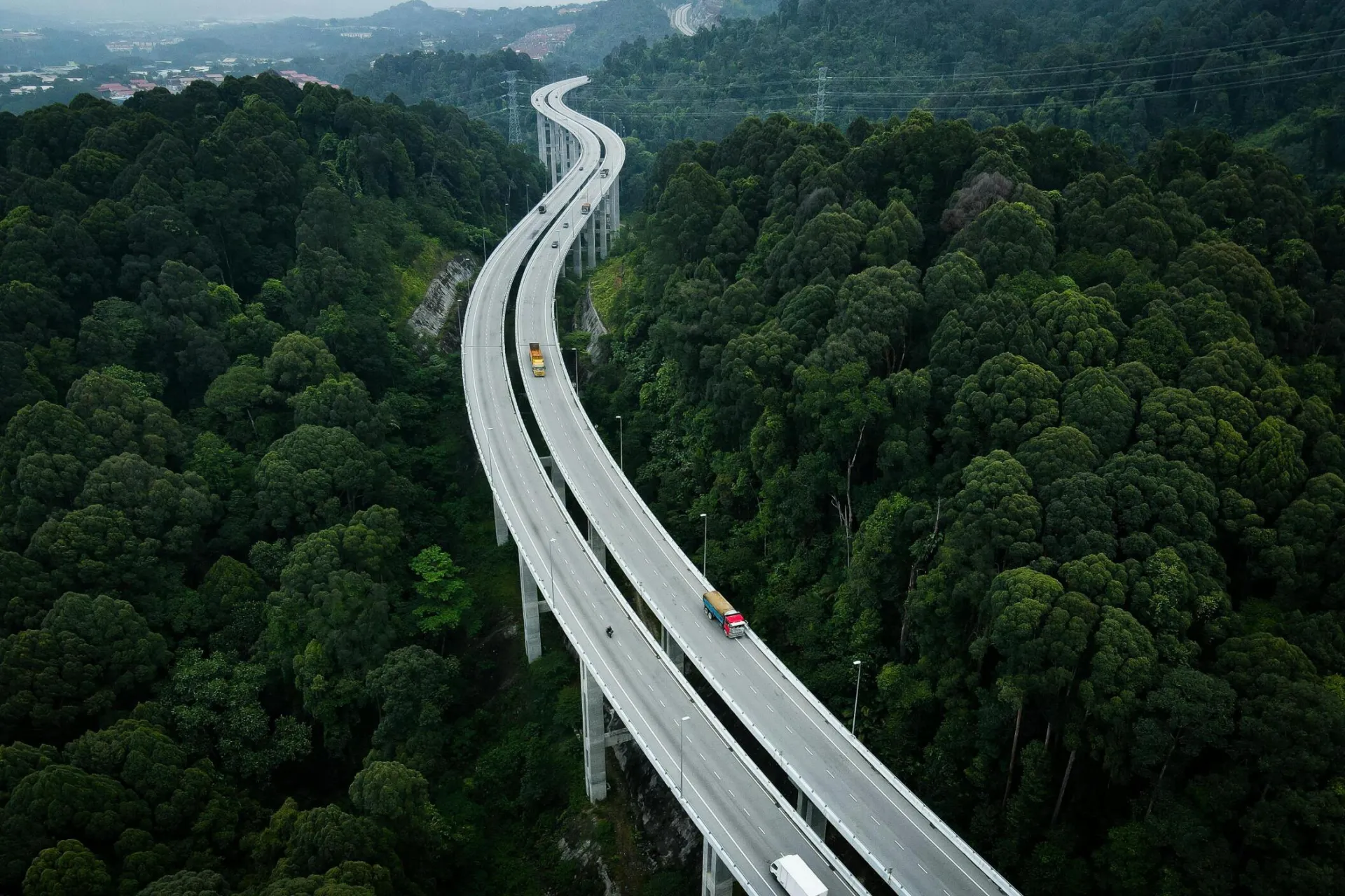 Aerial view of a highway cutting through lush forests in Rawang, Selangor, Malaysia.