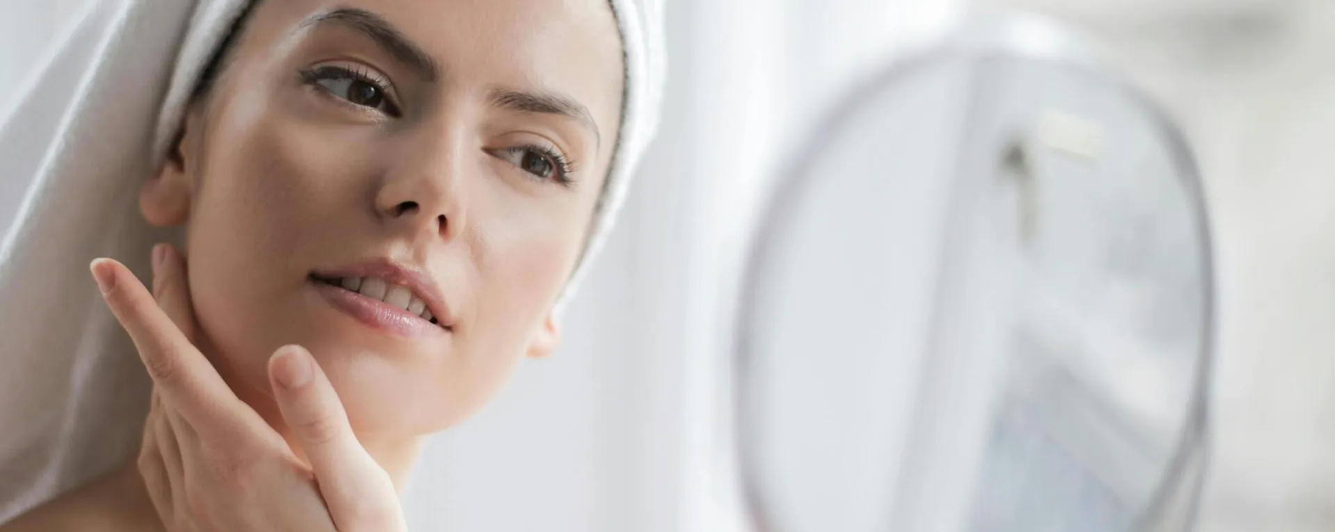 A serene and elegant woman enjoys a skincare ritual, enhancing her natural beauty in the comfort of her home.