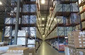 Wide angle view of a warehouse with stocked shelves and boxes.