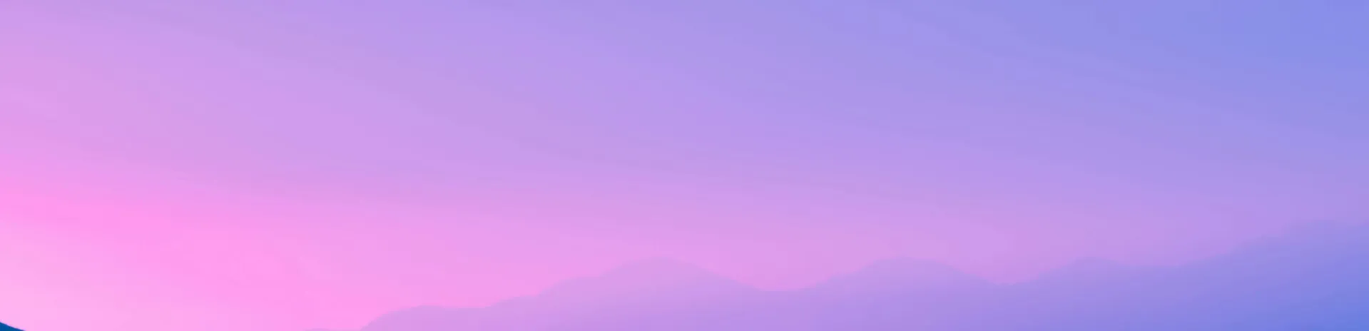 A beautiful silhouette of mountains against a gradient sky in purple and pink shades.