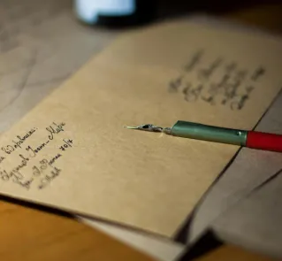 Close-up of vintage letters with a pen and ink, showcasing classic handwriting.