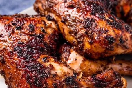 Appetizing barbecue chicken wings served with rich dipping sauce on rustic wooden board.