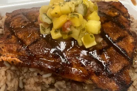 Delicious grilled salmon served with roasted vegetables and herb sauce.