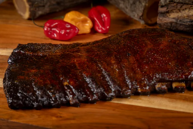 Close-up of flavorful sausages grilling on barbecue, perfect for a summer meal.