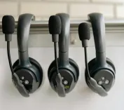Close-up of three black headsets with microphones, ideal for audio production and communications.
