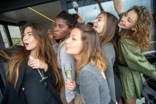 Group of women celebrating together with champagne indoors, expressing happiness and friendship.