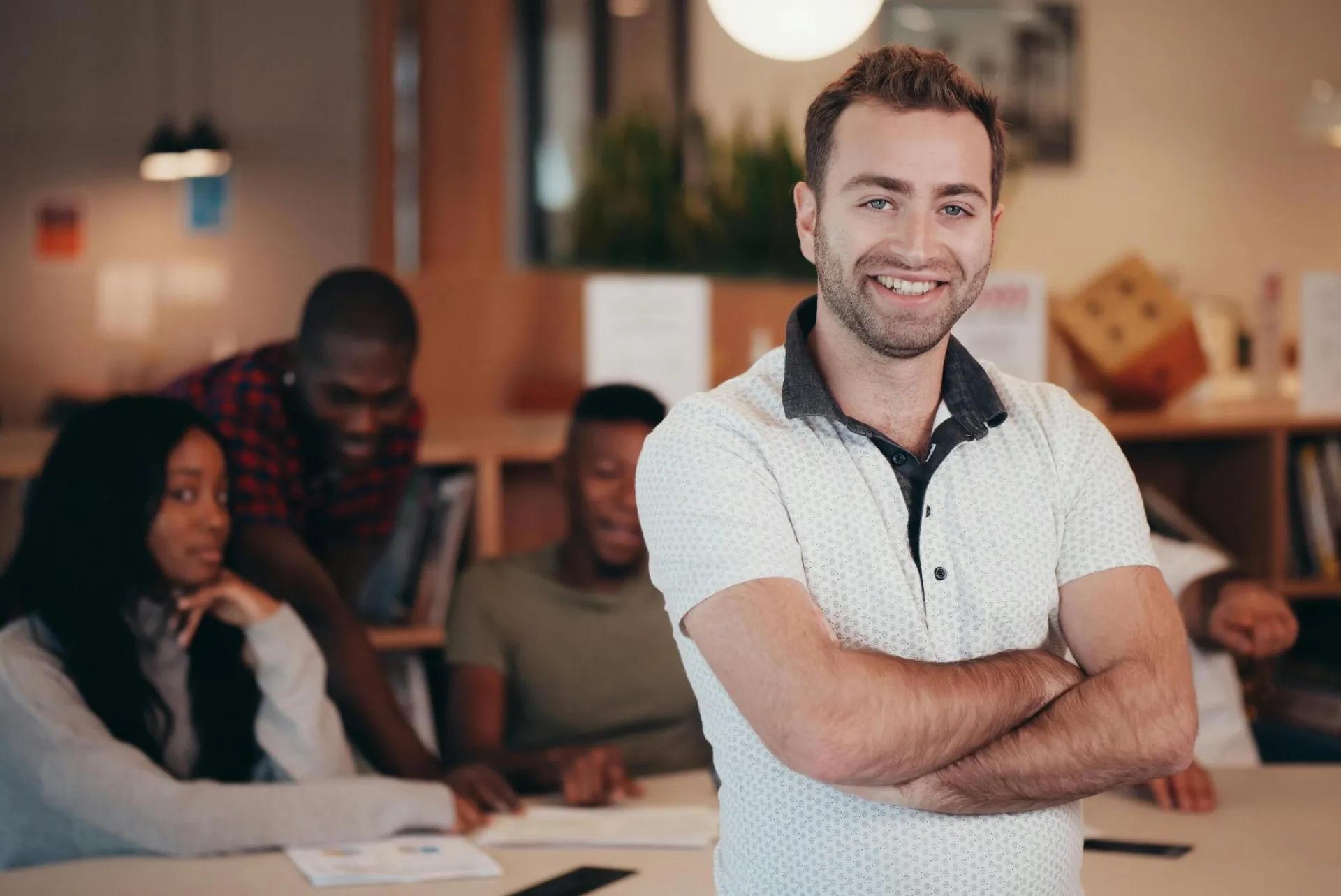 Confident professional with a team in a collaborative office setting, embodying leadership.