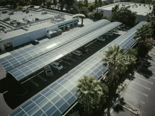 Aerial view of a parking lot with solar panel canopies, showcasing clean energy usage.