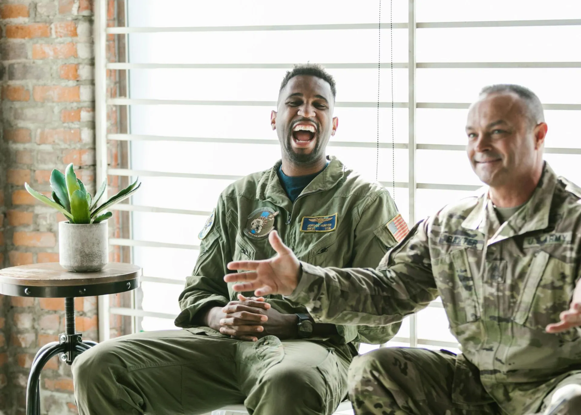 Two soldiers in therapy session, laughing and engaging, highlighting mental health support.