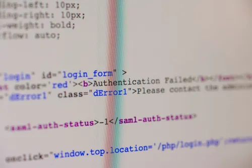 Close-up of HTML and PHP code on screen showing error message and login form data.