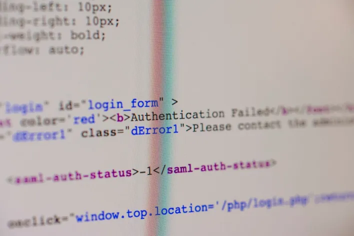 Close-up of HTML and PHP code on screen showing error message and login form data.
