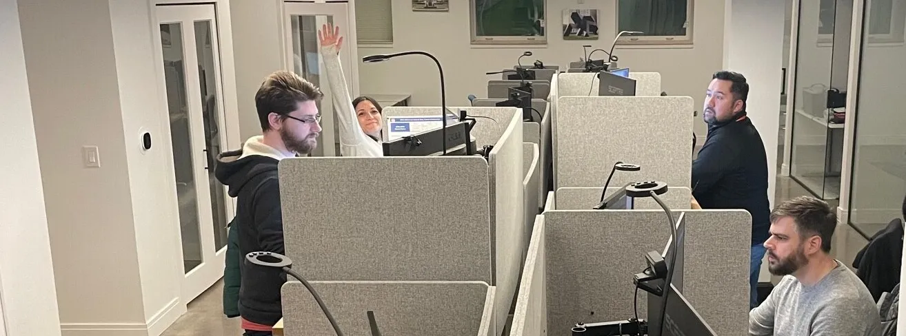 A team collaborates around a laptop for project discussion in a modern office.