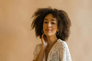 Portrait of a stylish young woman in a polka dot dress, embodying elegance and confidence.