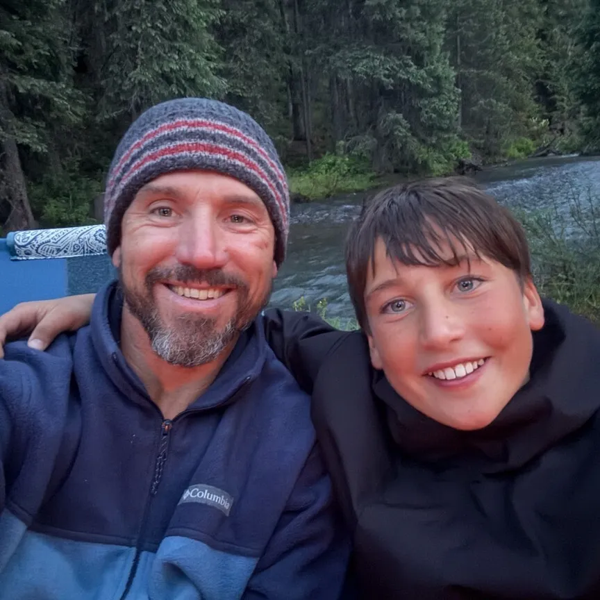 father and son taking a selfie with a river in the background