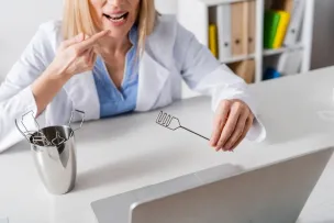 Doctor utilizing teletherapy to point at her mouth and educate
