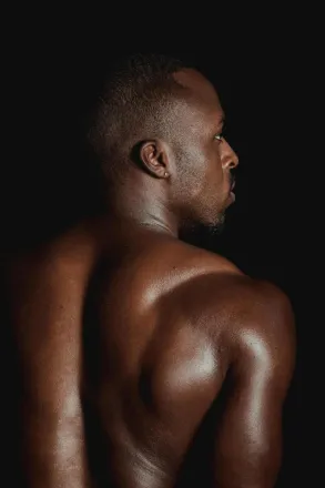 A powerful studio shot showcasing the muscular back of an African male model.