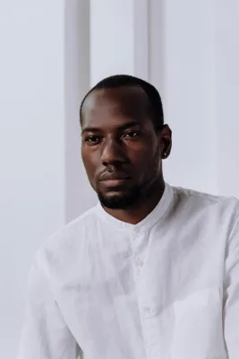 Serious business portrait of a man in a white shirt with minimalist background.