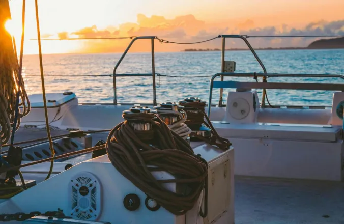 A serene view of a yacht deck during sunset in French Polynesia's Windward Islands.