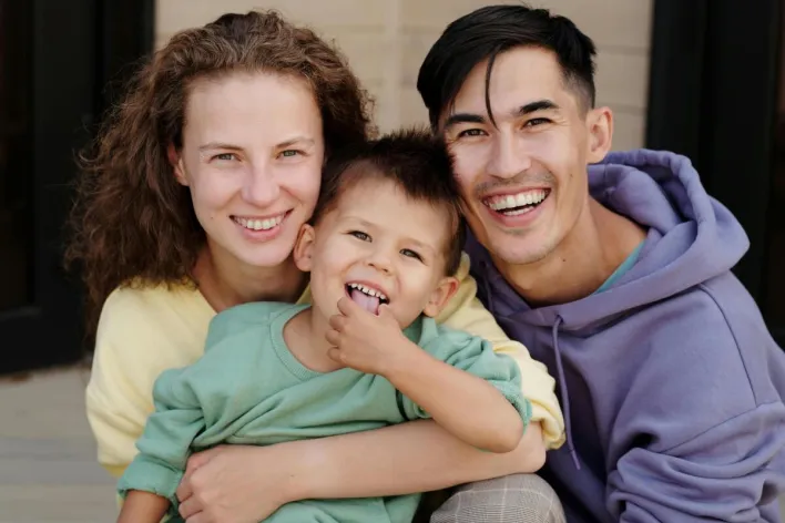 Cheerful family enjoying quality time together with bright smiles and warm embrace.