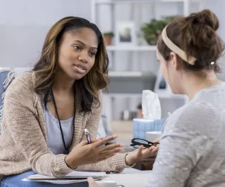 A therapist and client in discussion during a cozy indoor session highlighting mental health.