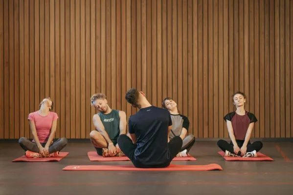 A diverse group of people practicing yoga indoors, focusing on relaxation and fitness.