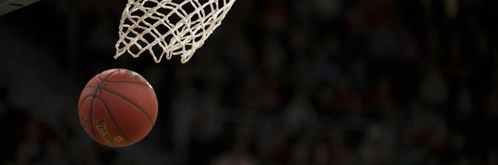 A basketball going through the hoop during a fast-paced game, capturing the excitement of the sport.