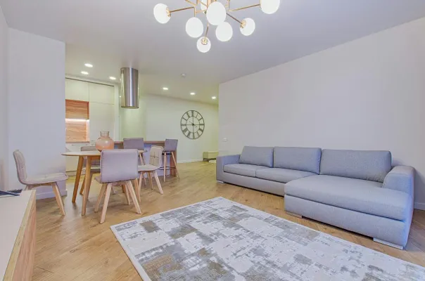 Spacious contemporary living room featuring stylish furniture and elegant lighting.