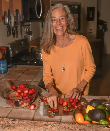 A close-up of a person holding fresh green almond pods in their hand, showcasing organic produce.