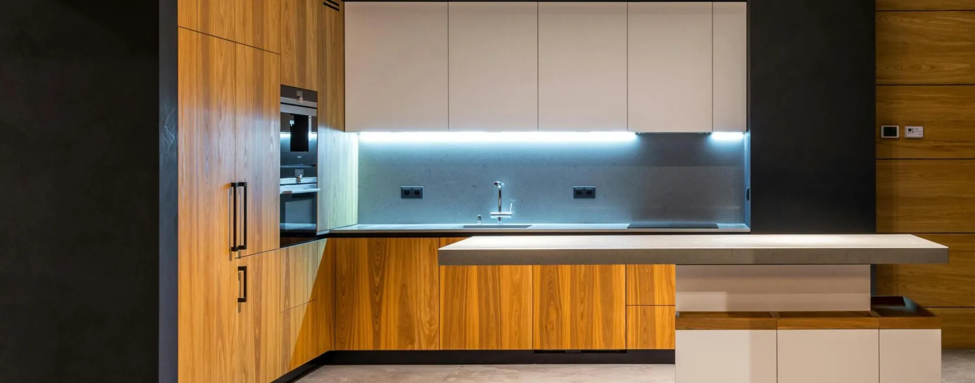 Interior of modern cottage with marble floor and spacious kitchen with wooden furniture and floating tabletop