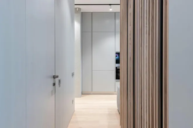 Modern empty hallway interior with door and walls leading to light spacious room