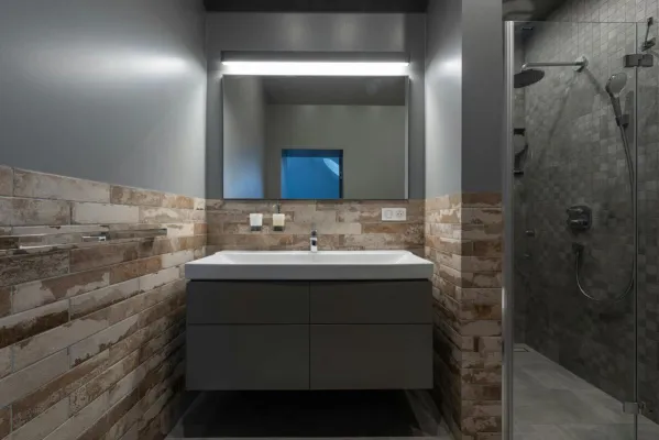 Contemporary bathroom with a glass shower and illuminated mirror.