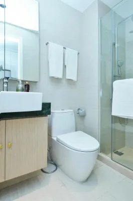 A sleek and clean modern bathroom featuring a shower, toilet, and sink.
