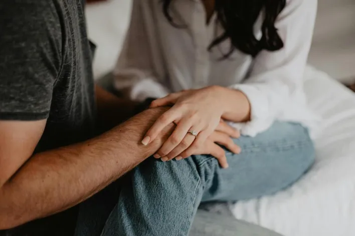 A tender moment of a couple holding hands, symbolizing love and connection.