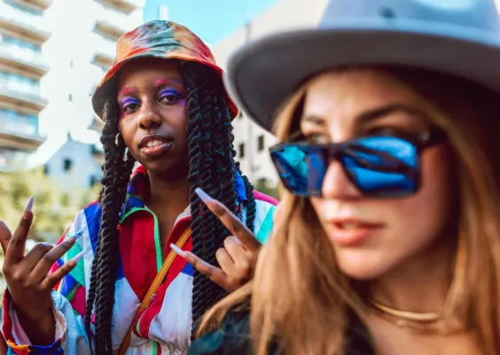 Young adults in vibrant street fashion enjoying a summer day outdoors.