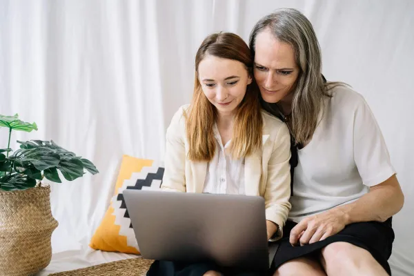 Smiling couple using a laptop together indoors. Inclusive LGBTQ representation in a cozy setting.