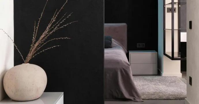 Comfortable soft big bed and small wooden bedside table with carpet in bedroom