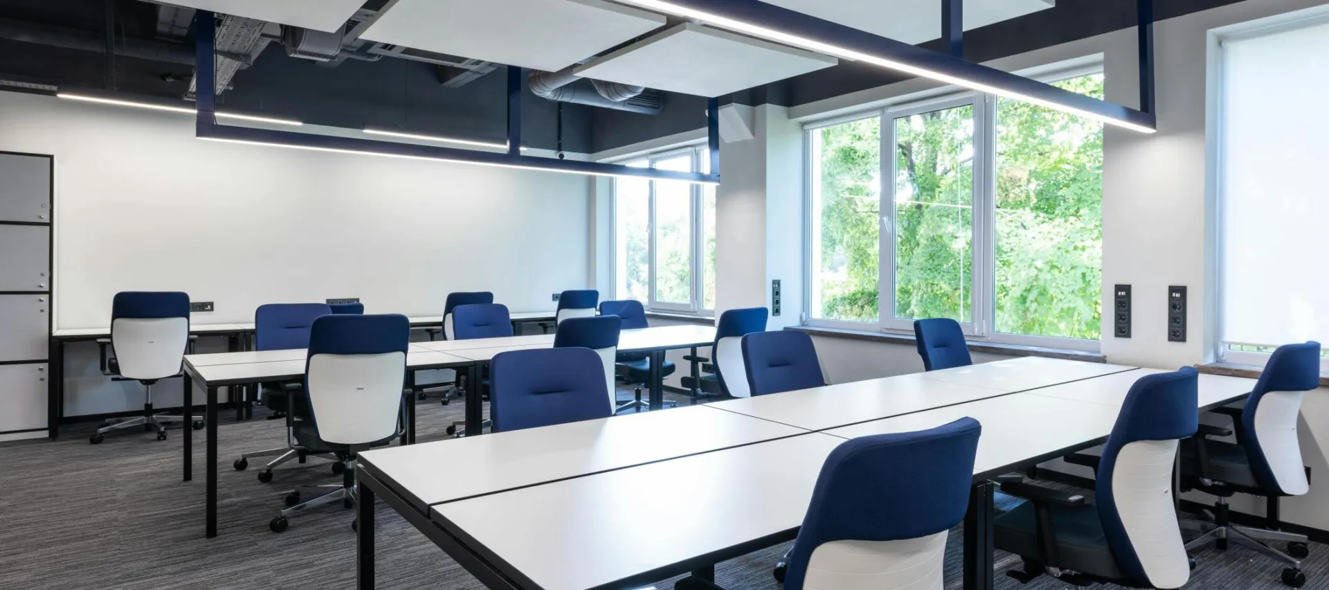Spacious, modern office interior with blue chairs and ample natural light.
